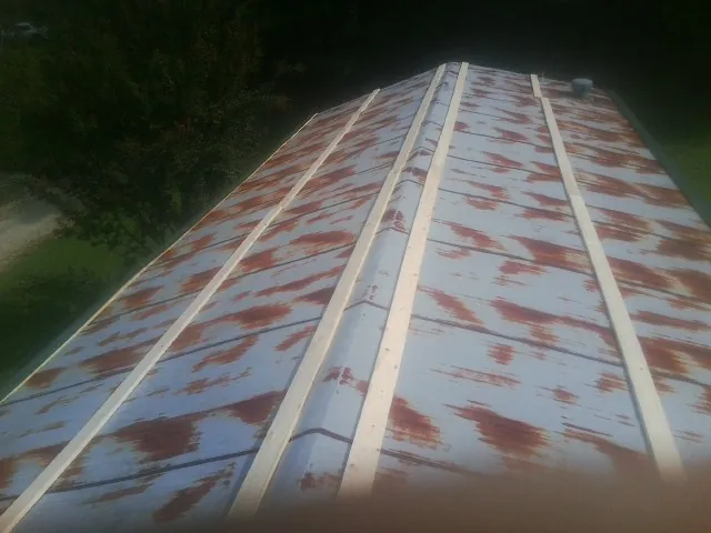 Rusted metal roof panels with new wood purlins before replacement — Storm Damage Roof Repair in Waunakee by Roofing Brothers
