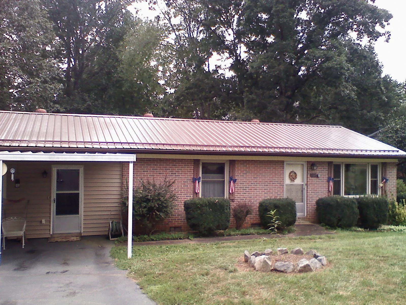Bronze metal roof and carport on a brick ranch home — Roof Repair work by our crew in Waunakee