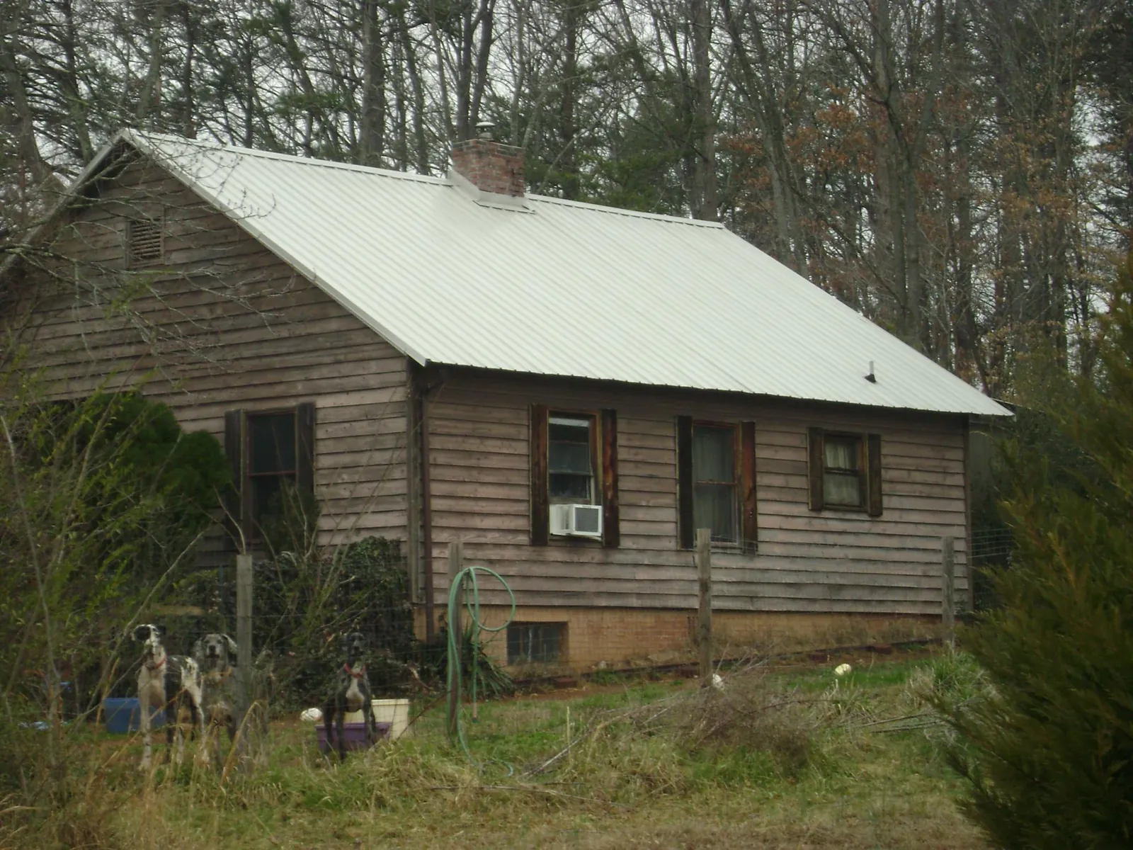 White metal roof on an old wood sided farmhouse, from a Metal Roof Installation job in Waunakee